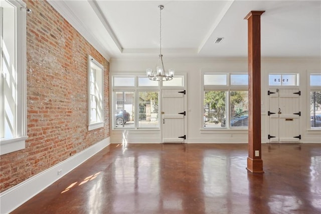 entryway with ornate columns, a chandelier, baseboards, finished concrete flooring, and brick wall