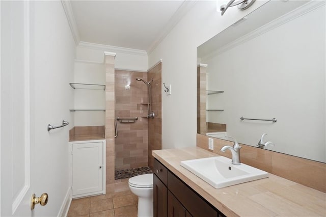 bathroom with crown molding, tiled shower, toilet, vanity, and tile patterned floors