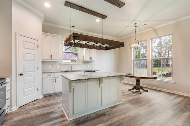 31527 Meadow Lark Ln, Denham Springs, LA 70726 - kitchen featuring white cabinetry, decorative backsplash, visible vents, light wood-style floors, and a center island