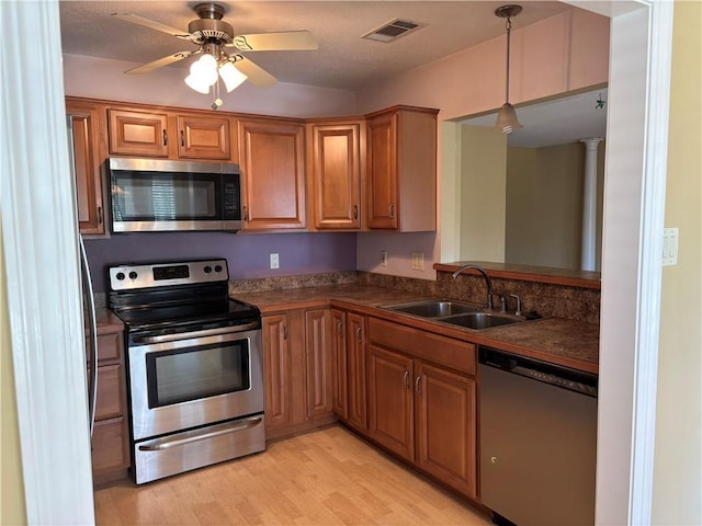 416 Marina Dr, Slidell, LA 70458 - kitchen featuring a sink, appliances with stainless steel finishes, brown cabinetry, dark countertops, and visible vents