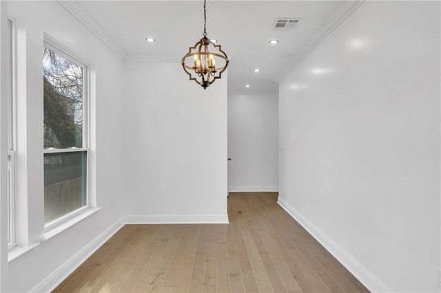 8820 Cohn St, New Orleans, LA 70118 - unfurnished dining area with an inviting chandelier, ornamental molding, baseboards, visible vents, and wood finished floors