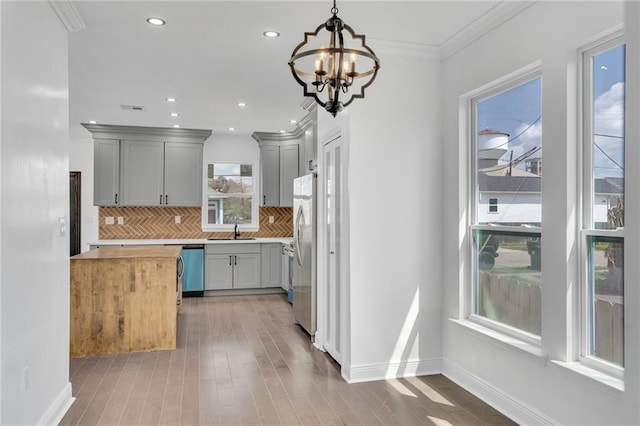 8820 Cohn St, New Orleans, LA 70118 - kitchen featuring crown molding, a sink, tasteful backsplash, dishwashing machine, and butcher block counters