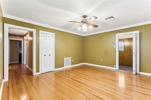 spare room featuring attic access, visible vents, light wood-type flooring, and a ceiling fan