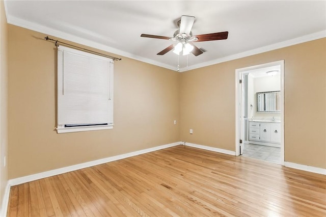 spare room featuring baseboards, light wood-style flooring, and ornamental molding