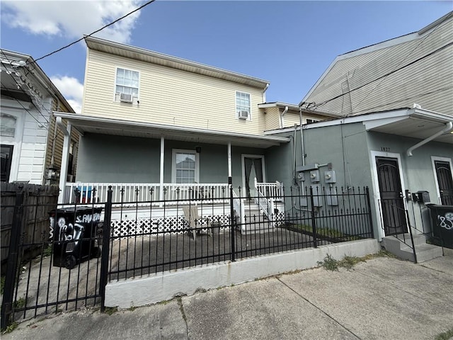 1827 S Rampart St, New Orleans, LA 70113 - townhome / multi-family property featuring a fenced front yard, cooling unit, and covered porch