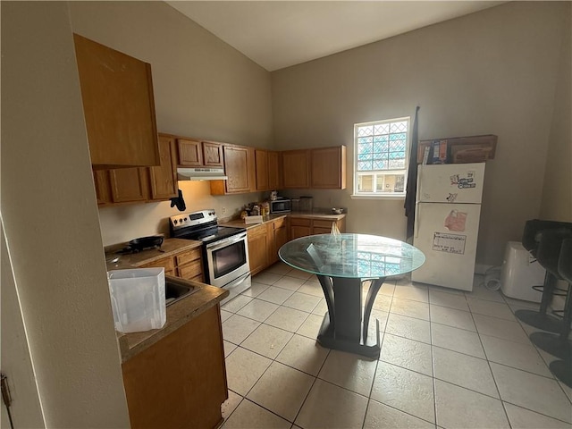 1827 S Rampart St, New Orleans, LA 70113 - kitchen with electric range, freestanding refrigerator, under cabinet range hood, a sink, and brown cabinets