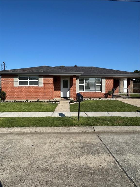 3020 Decomine Dr, Chalmette, LA 70043 - ranch-style house featuring brick siding, a front lawn, an attached carport, and concrete driveway