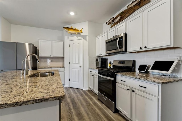 kitchen featuring white cabinets, tasteful backsplash, a sink, and appliances with stainless steel finishes