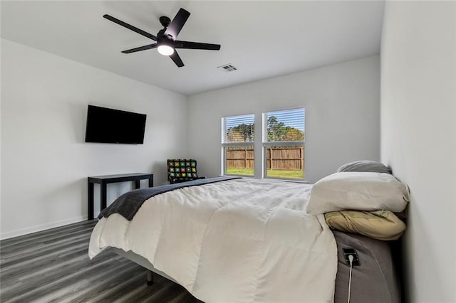bedroom with visible vents, baseboards, a ceiling fan, and dark wood-style floors