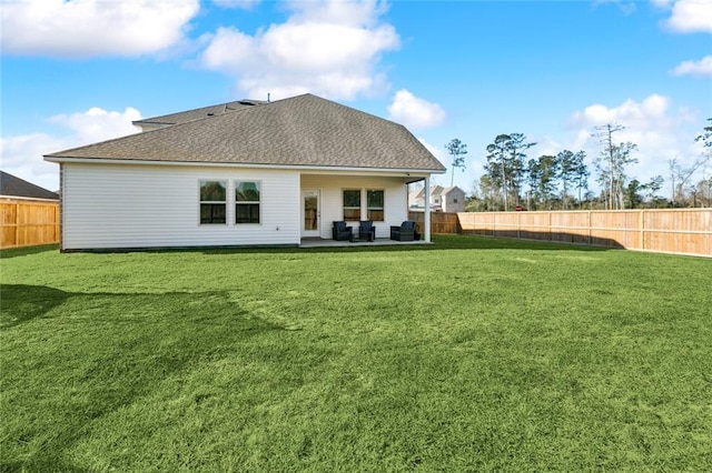 rear view of property with a patio, a fenced backyard, roof with shingles, and a lawn