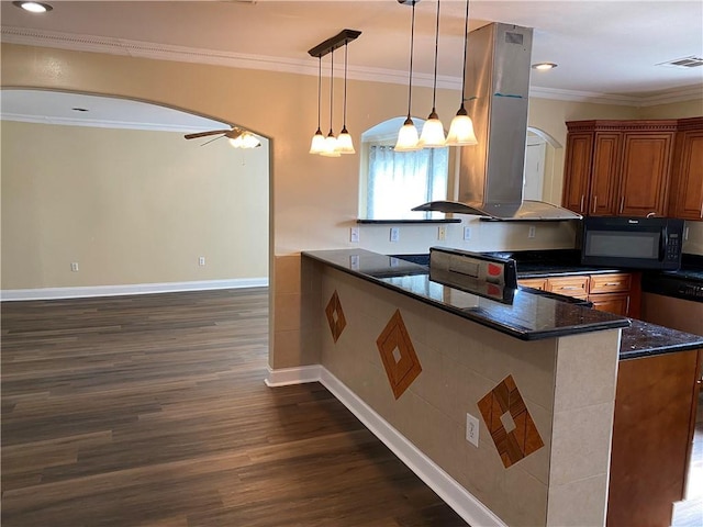 1569 Athis St, New Orleans, LA 70122 - kitchen with arched walkways, black microwave, wall chimney range hood, crown molding, and dark wood finished floors