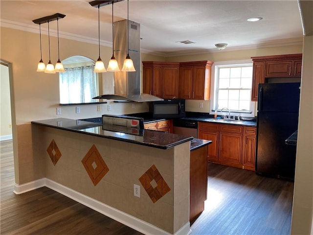 1569 Athis St, New Orleans, LA 70122 - kitchen with black appliances, wall chimney range hood, brown cabinetry, dark wood-style flooring, and ornamental molding