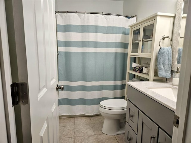 full bathroom featuring toilet, tile patterned floors, vanity, and curtained shower