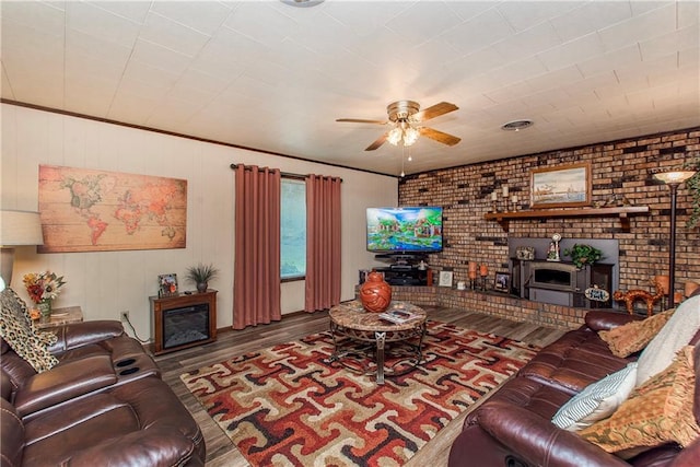 59345 Twin Pines Rd, Bogalusa, LA 70427 - living room with a fireplace, wood finished floors, ceiling fan, and brick wall