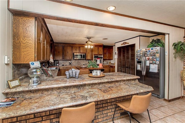 59345 Twin Pines Rd, Bogalusa, LA 70427 - kitchen featuring crown molding, ceiling fan, a peninsula, appliances with stainless steel finishes, and brown cabinets