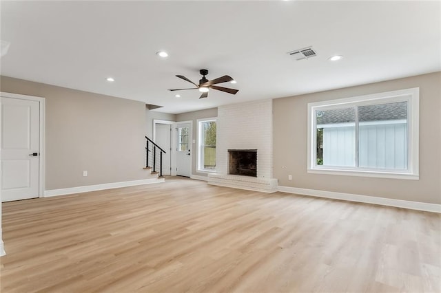 156 Belle Terre Blvd, Covington, LA 70433 - unfurnished living room featuring baseboards, stairway, light wood-style floors, a brick fireplace, and recessed lighting