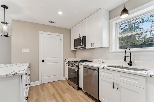 156 Belle Terre Blvd, Covington, LA 70433 - kitchen with appliances with stainless steel finishes, a sink, light stone counters, white cabinetry, and recessed lighting