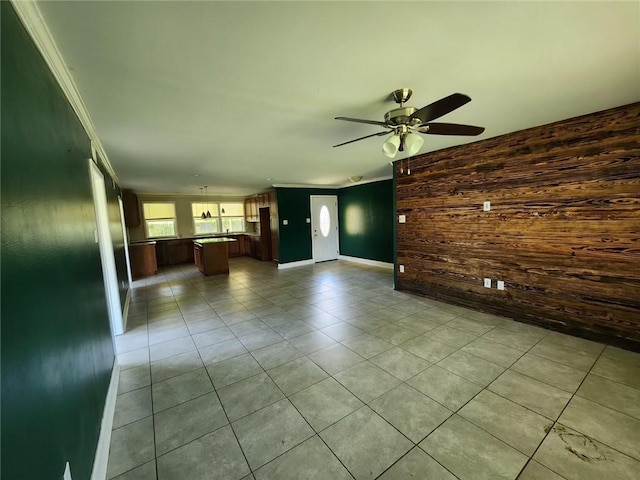167 Celia Dr, Luling, LA 70070 - unfurnished living room with light tile patterned flooring, wood walls, baseboards, ornamental molding, and a ceiling fan