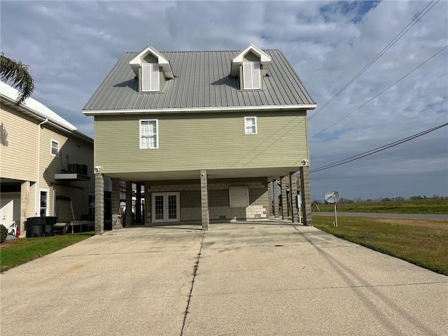 100 Deer Range Ln, Port Sulphur, LA 70083 - raised beach house with metal roof, french doors, driveway, and a carport