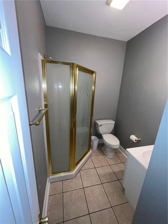100 Deer Range Ln, Port Sulphur, LA 70083 - full bath featuring baseboards, tile patterned flooring, a stall shower, and toilet