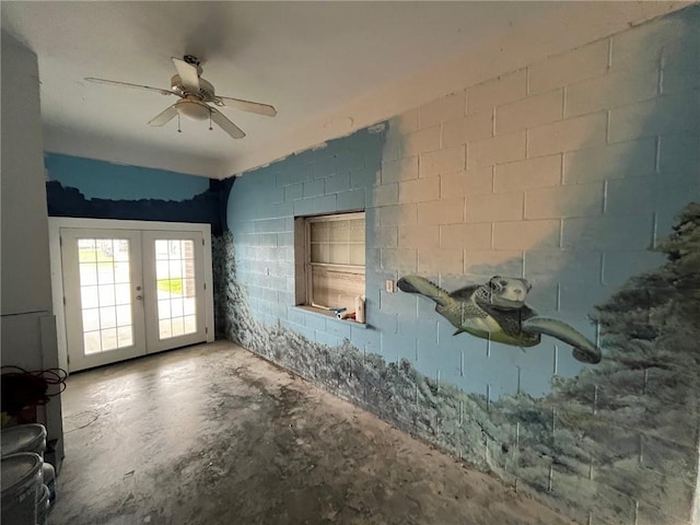 100 Deer Range Ln, Port Sulphur, LA 70083 - interior space featuring french doors, concrete block wall, ceiling fan, and unfinished concrete floors