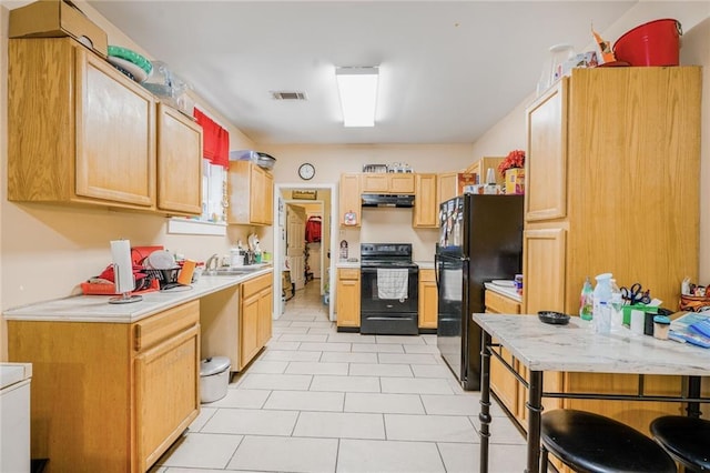 1983 Law St, New Orleans, LA 70119 - kitchen with light countertops, under cabinet range hood, black appliances, and visible vents