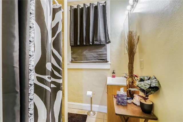 1983 Law St, New Orleans, LA 70119 - bathroom with baseboards, a shower with shower curtain, tile patterned flooring, and vanity