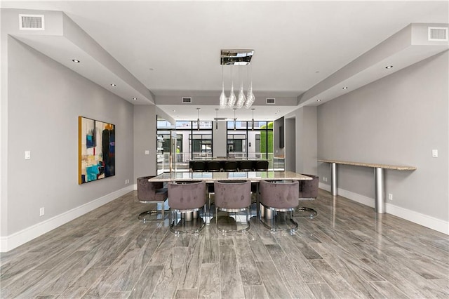 bar with a raised ceiling, baseboards, decorative light fixtures, and visible vents
