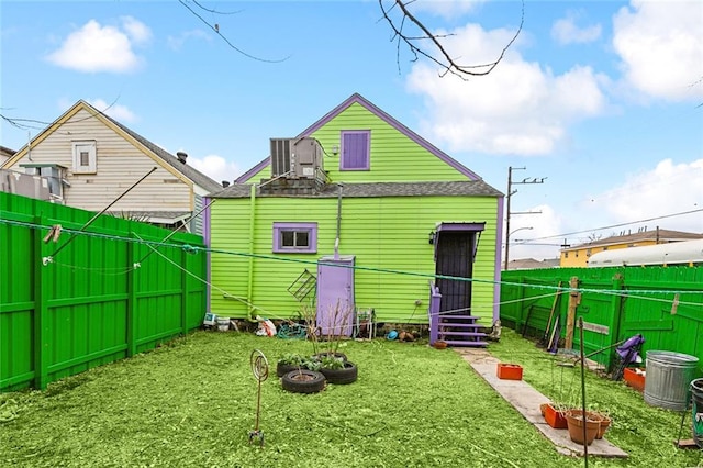 2725 Philip St, New Orleans, LA 70113 - rear view of property featuring a yard, roof with shingles, and a fenced backyard