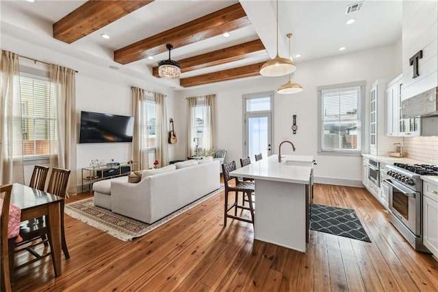 125 Elmira Ave, New Orleans, LA 70114 - kitchen with high end stove, recessed lighting, beam ceiling, a kitchen bar, and light countertops