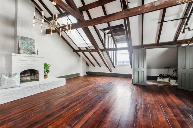 516 Governor Nicholls St Unit 401, New Orleans, LA 70116 - unfurnished living room with an inviting chandelier, stairs, a brick fireplace, hardwood / wood-style flooring, and lofted ceiling with beams