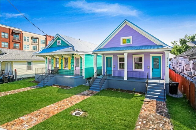 4235 Tulane Ave, New Orleans, LA 70119 - view of front facade with a porch, a front lawn, and metal roof