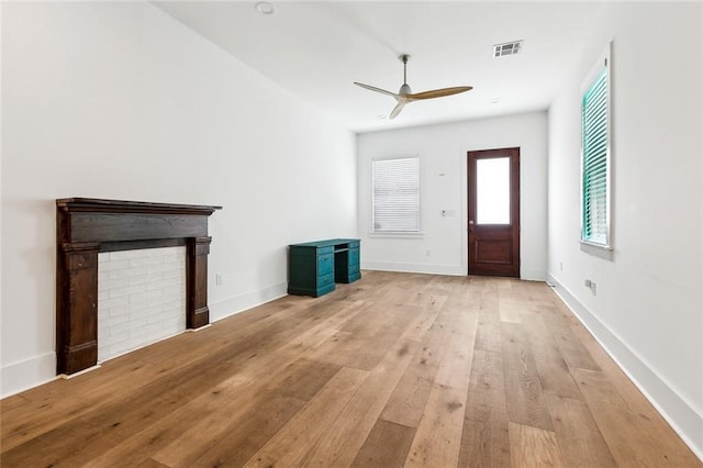 unfurnished living room featuring baseboards, light wood-type flooring, visible vents, and a ceiling fan