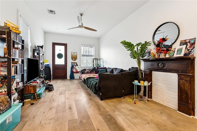 living area with hardwood / wood-style floors, a ceiling fan, and visible vents