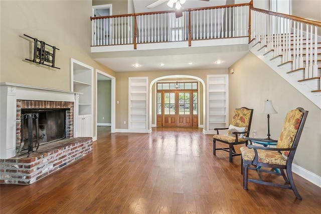 80055 Rollo Rd, Bush, LA 70431 - sitting room with wood-type flooring, baseboards, built in shelves, arched walkways, and a ceiling fan
