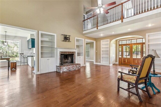 80055 Rollo Rd, Bush, LA 70431 - living room with baseboards, ceiling fan, arched walkways, built in features, and dark wood-style floors