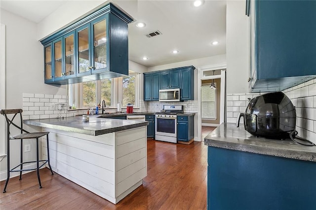 80055 Rollo Rd, Bush, LA 70431 - kitchen featuring blue cabinetry, dark wood finished floors, visible vents, a peninsula, and appliances with stainless steel finishes