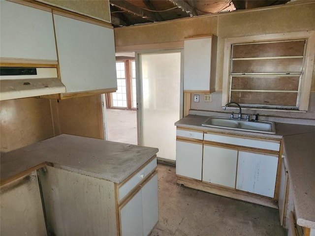 602 6th St, Pearl River, LA 70452 - kitchen featuring under cabinet range hood, a sink, white cabinets, and concrete floors