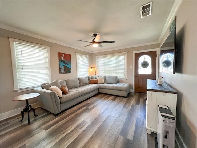 living area with dark wood-style flooring, ornamental molding, ceiling fan, and visible vents