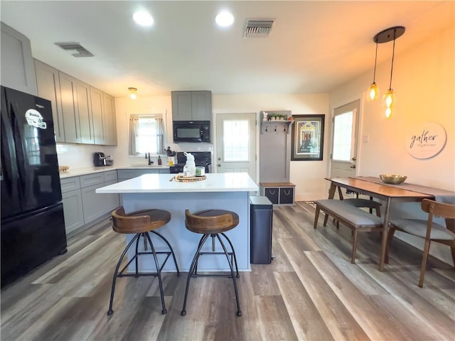 kitchen with visible vents, black appliances, and light countertops