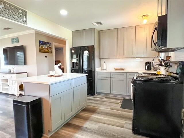 kitchen with light countertops, black appliances, gray cabinetry, and visible vents