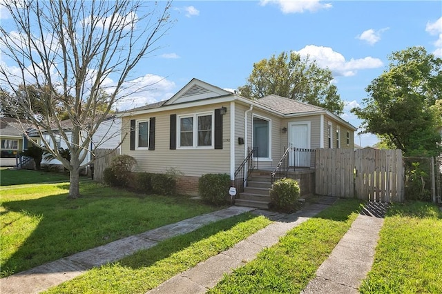 bungalow-style house featuring fence and a front lawn