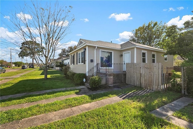 bungalow-style house with fence and a front yard