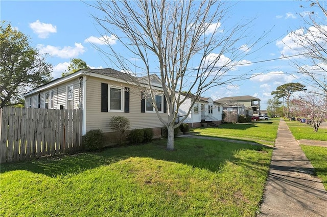 view of side of property featuring fence and a yard