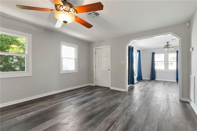 unfurnished room featuring dark wood-style flooring, visible vents, baseboards, and ceiling fan