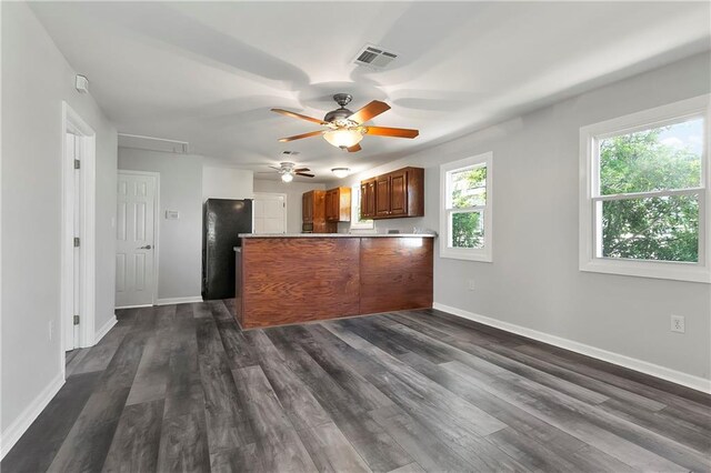 kitchen featuring baseboards, visible vents, dark wood-style floors, ceiling fan, and a peninsula