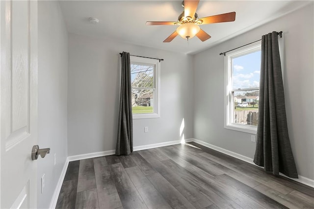unfurnished room featuring a ceiling fan, dark wood-style floors, and baseboards