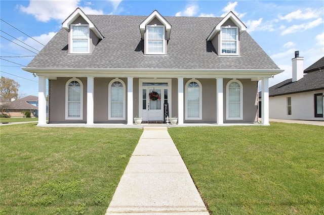 cape cod-style house featuring stucco siding, a front yard, a porch, and roof with shingles