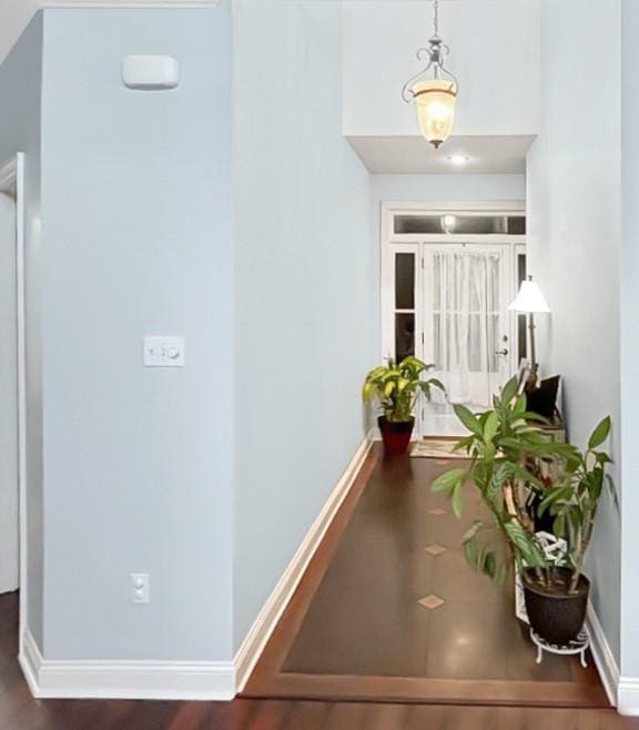 hallway featuring baseboards and wood finished floors