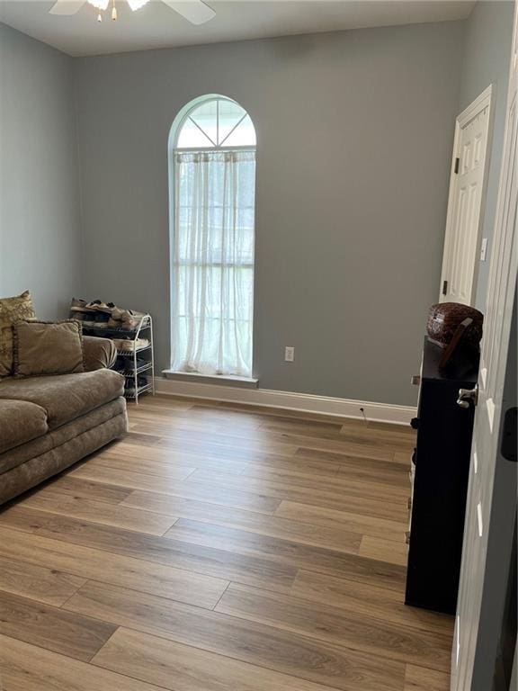 interior space with baseboards, ceiling fan, and wood finished floors